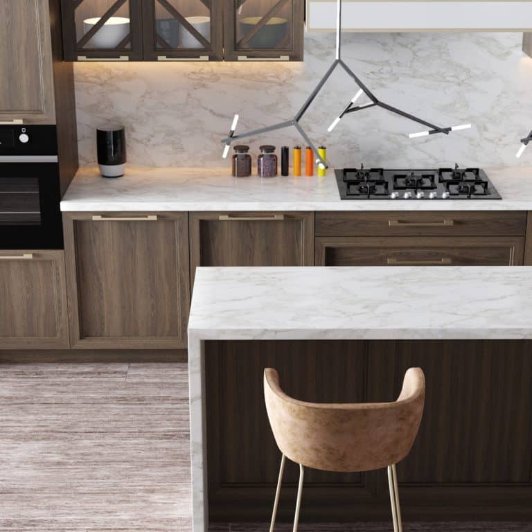 Cuisine moderne élégante avec îlot en marbre blanc, meubles en bois foncé, four encastré, plaque de cuisson à gaz et luminaire design.